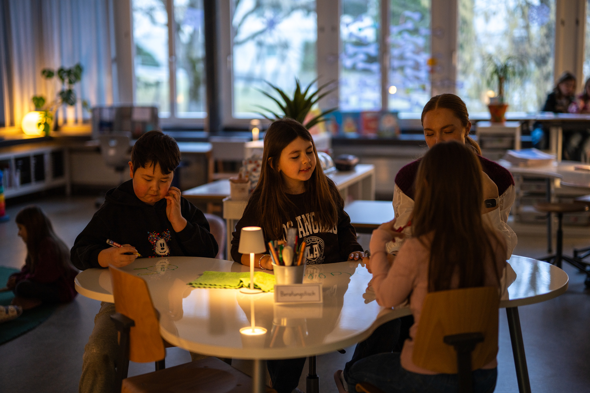 Unterrichtssituation mit Lehrerin und Kindern in einer Lernumgebung nach dem Churermodell