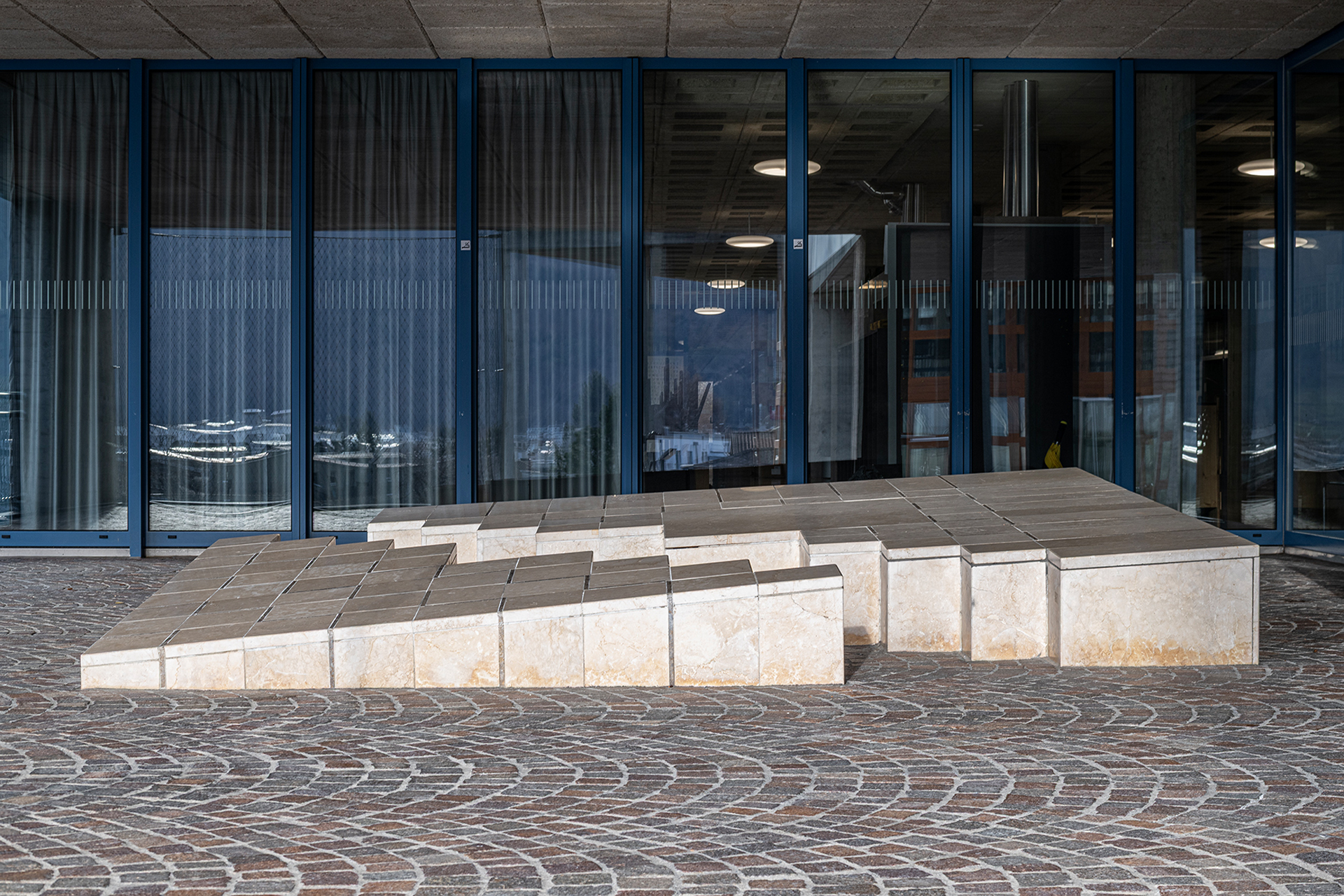 Adriana Grass-Marques, ohne Titel, 1983, aufgebrochener Quader, Inkrustation, Kalkstein, am Gebäude der Pädagogischen Hochschule Graubünden