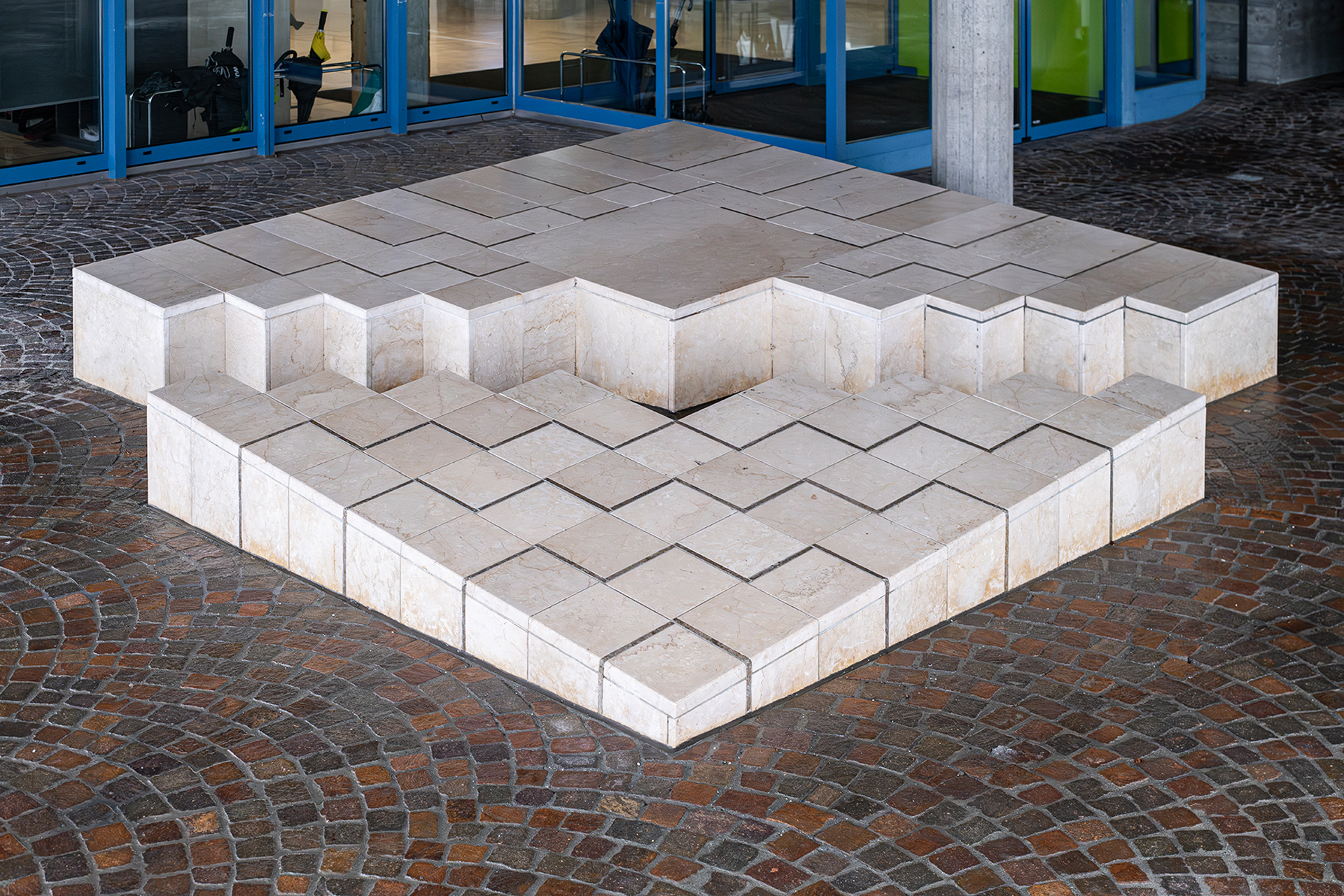 Adriana Grass-Marques, ohne Titel, 1983, aufgebrochener Quader, Inkrustation, Kalkstein, am Gebäude der Pädagogischen Hochschule Graubünden